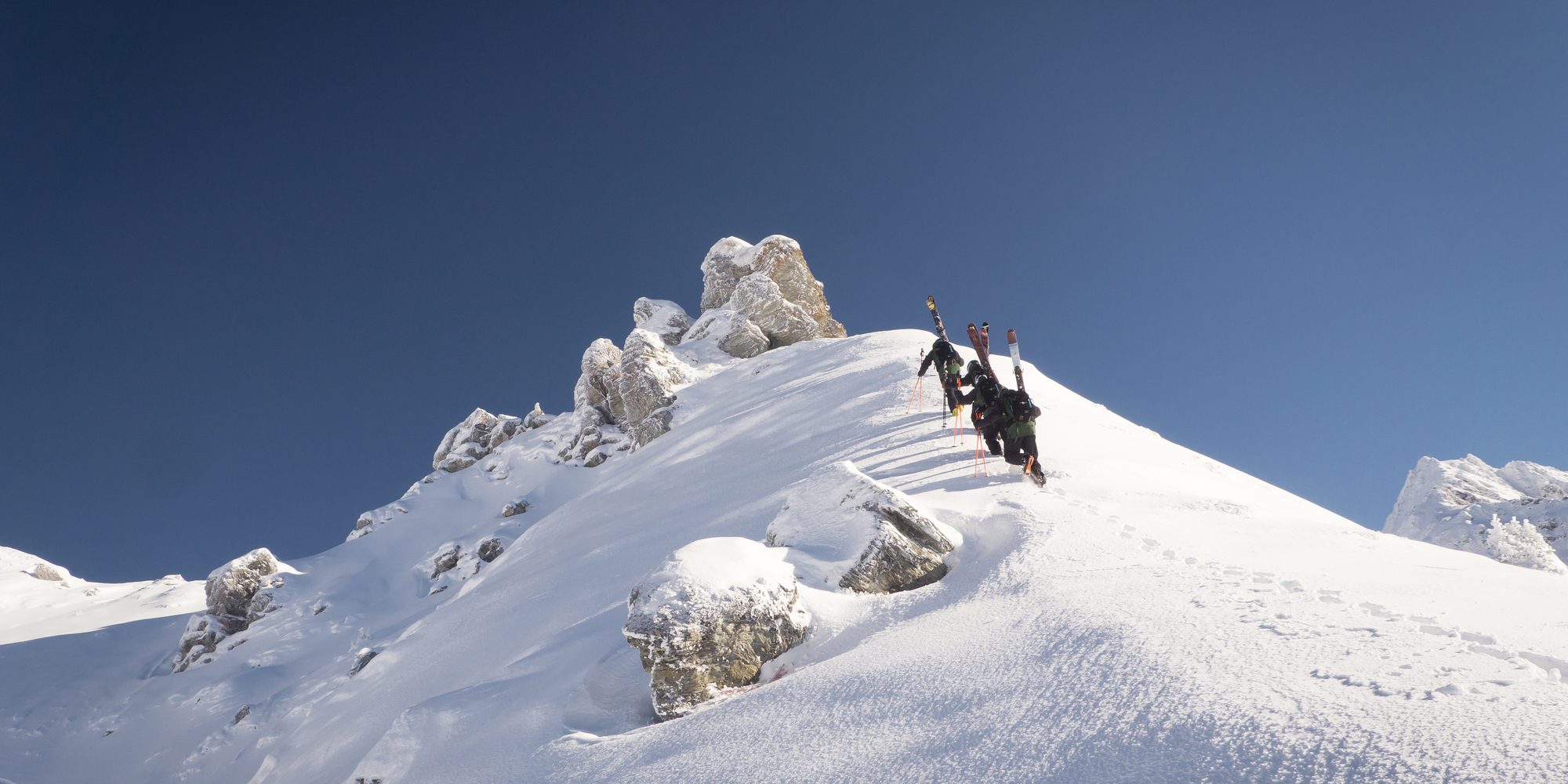 A corniced summit ridge above Verbier under a clear sky